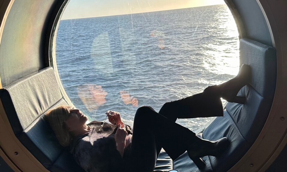 November 2023 TCM cruise: Kim relaxes while enjoying the view of the sea through a porthole of the Disney Magic / TCM ship on a November 2023 Mexico cruise